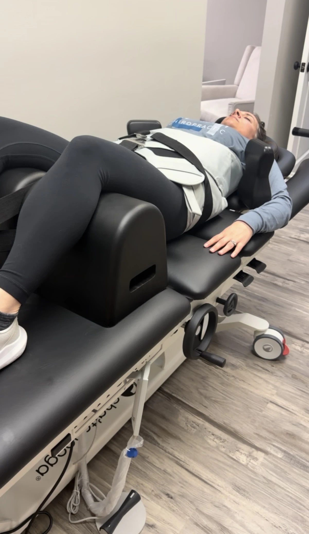 A woman lying in a spinal decompression table