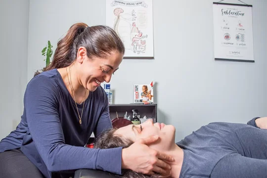 Dr. Nora Zoma adjusting a patient's neck